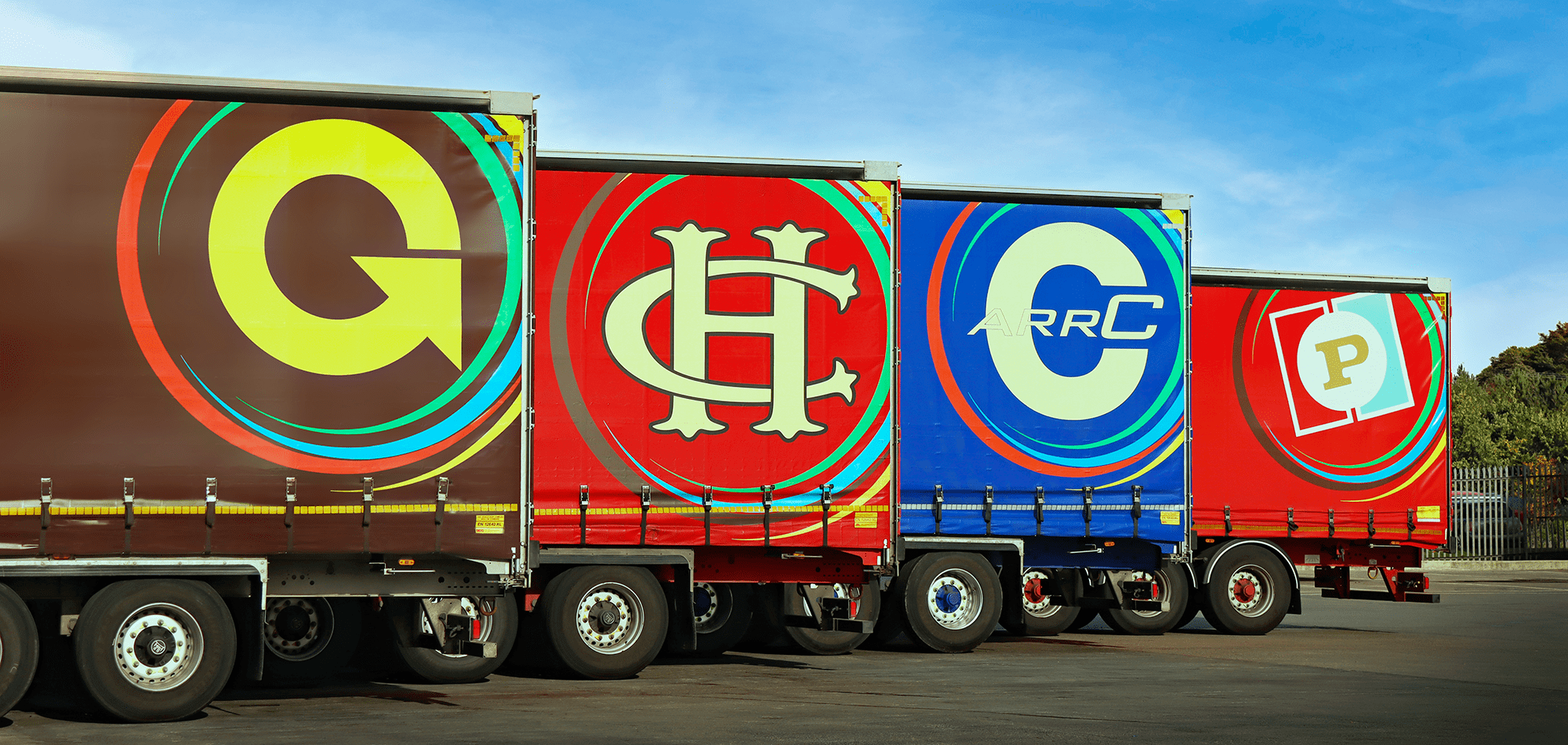 Side view of trailers of four Gregory Group brands.