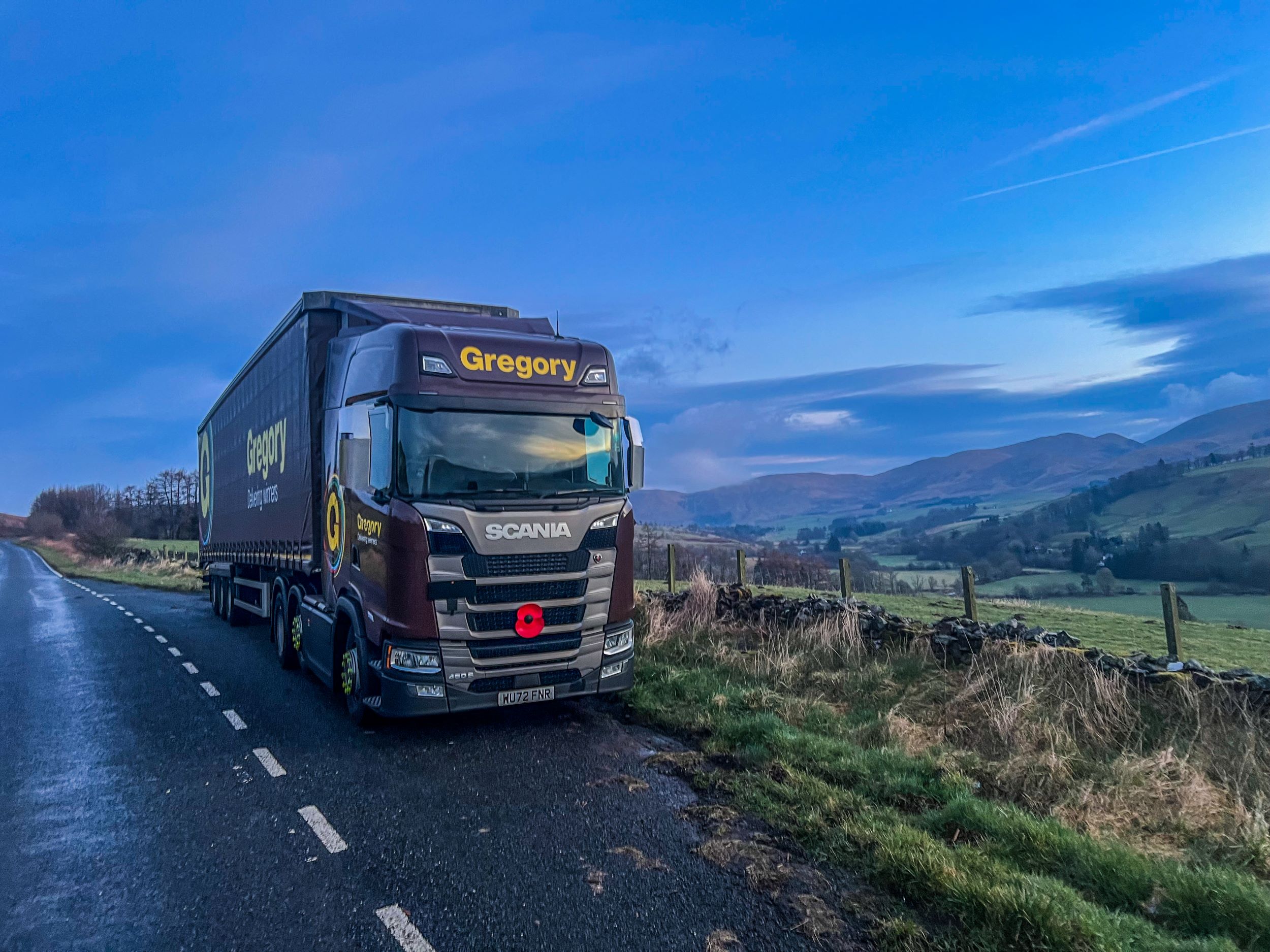 Gregory truck parked at side of scenic road.
