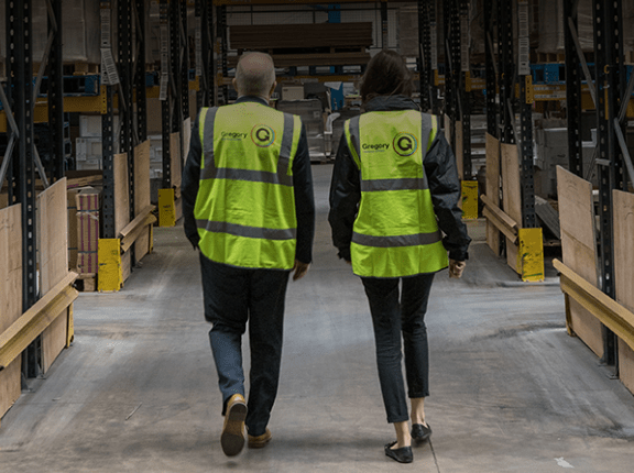 Two people walking through warehouse.