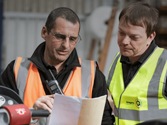 two people reviewing paperwork in warehouse.