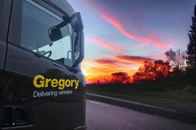 Gregory Group Delivering Winners on cab with sun setting.